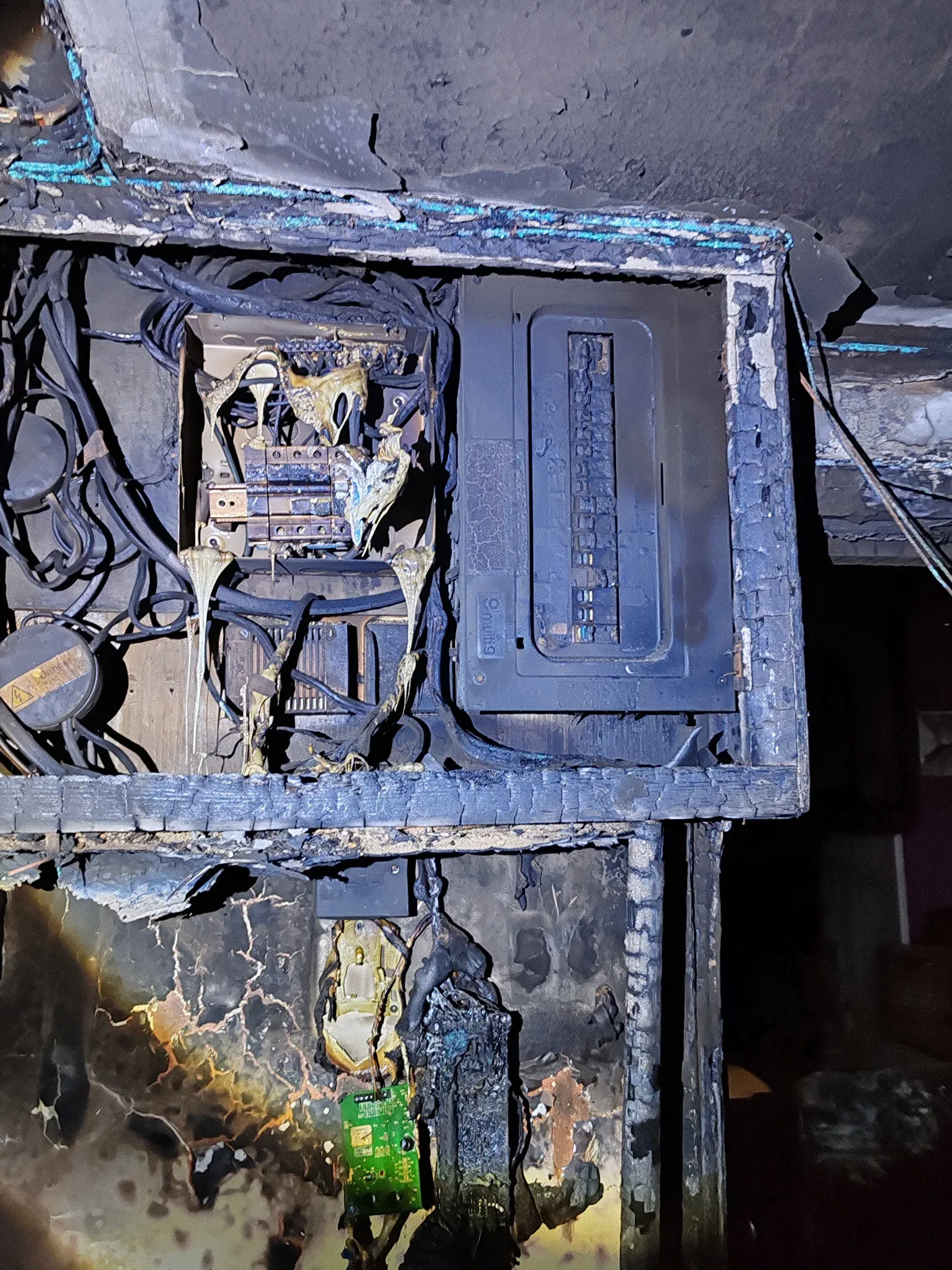 Consumer unit showing fire damage and melted components following sustained arcing at a loose neutral connection