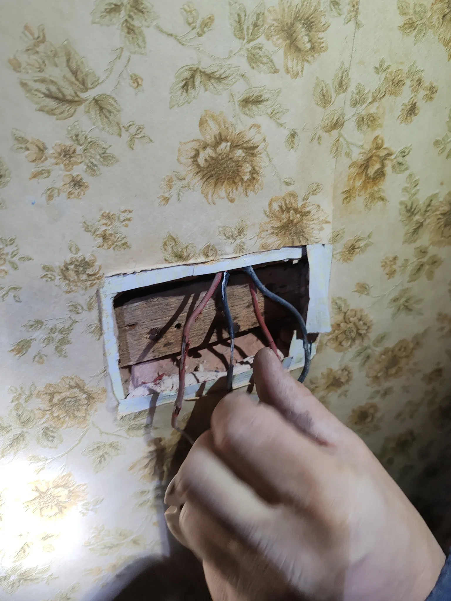 Pre-1960s rubber-insulated red and black wiring exposed during strip-out on a house rewire in Leicester, January 2025